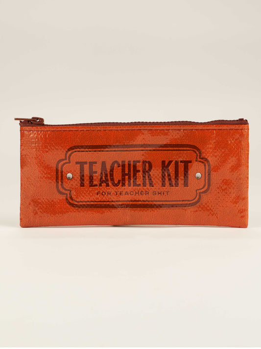 The Blue Q Teacher Kit Pencil Case is a red zippered pouch with "Teacher Kit for Teacher Shit" printed in black—a fun way to store teacher supplies or use as a classroom kit. Shown against a plain, light background.