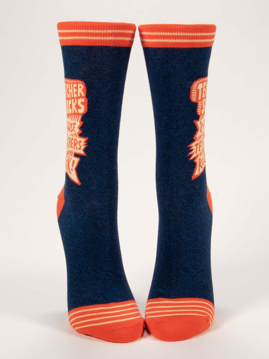 Blue Q’s Teacher Socks 'Cause Teachers Rock W-Crew Socks feature navy blue combed cotton with orange toes, heels, cuffs, and stripes plus an orange and white “Teacher Rocks!” design on the sides.