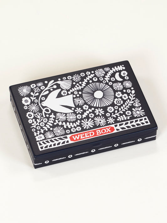 The Weed Box Pocket Box by Blue Q is a black storage box featuring white floral and bird designs, with "WEED BOX" in bold red and white on the front—perfect for organizing pre-rolls. Displayed against a light background.