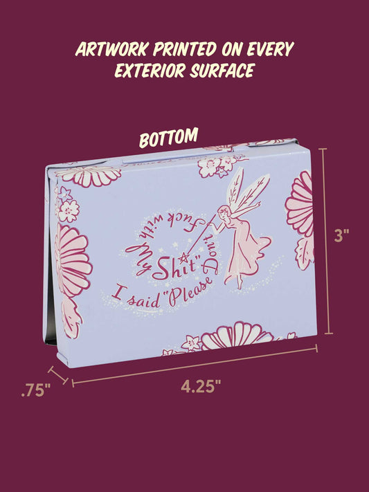 The Blue Q “Please Don’t Fuck With My Shit Pocket Box” is a rectangular wallet with fairy art and bold text on lavender; measures 4.25" x 3" x 0.75". A cheeky, compact gift for anyone with a sense of humor.