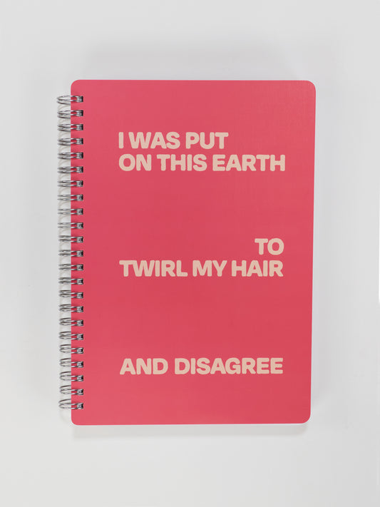 The Blue Q "I Was Put On This Earth To Twirl My Hair And Disagree" 6x8 spiral notebook features a bold, quirky cover—perfect for motivation or desk decor.