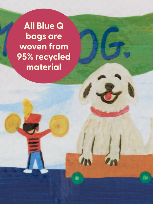A cheerful illustration of a smiling dog in a wagon next to a toy soldier with cymbals captures the playful spirit found on the Blue Q “I Love My Dog. My Dog Loves Butts.” Pencil Case. A pink circle highlights that all Blue Q bags are made from 95% recycled material.