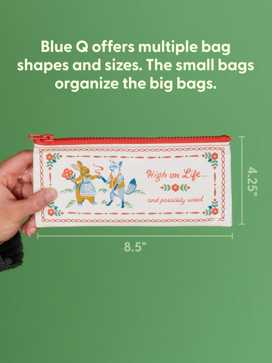 A hand holds the Blue Q “High On Life...And Possibly Weed Pencil Case,” a rectangular pouch measuring 8.5 by 4.25 inches, decorated with whimsical ducks and playful text that offers a cheeky nod to being high on life—or perhaps weed. Text above introduces other Blue Q bag options.