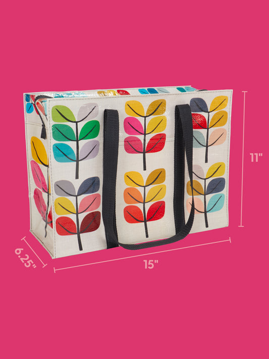 The Sprout Shoulder Tote by Blue Q features vibrant leaf patterns, sturdy black handles, and spacious dimensions of 15″ wide, 11″ tall, and 6.25″ deep. Set against a pink background, this colorful plant-themed tote is perfect for everyday use.