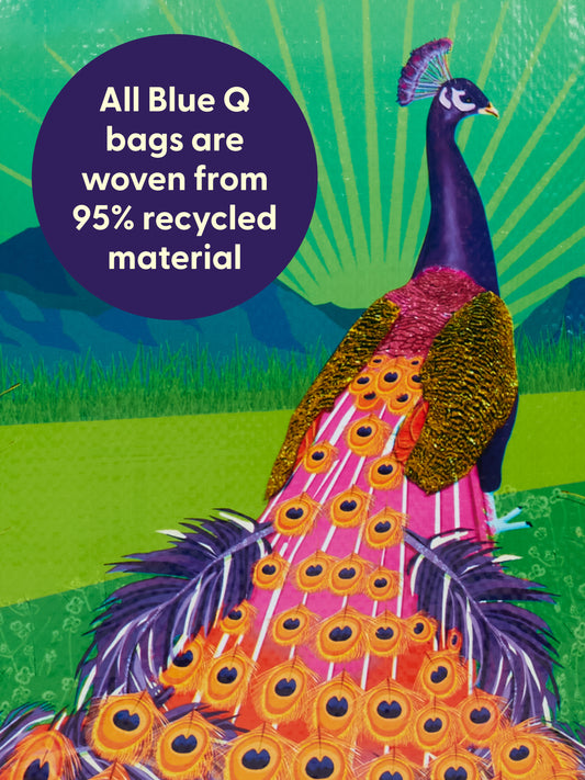 A vibrant Peacock Paradise Shopper by Blue Q features a peacock with a long, colorful tail on grass. A purple circle notes it's made from 95% recycled material. Green hills and radiant sunrays light up the background.