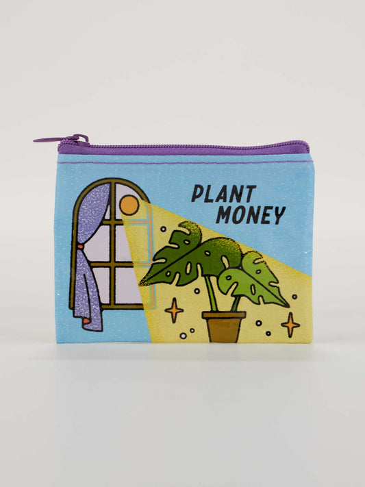The Blue Q Plant Money Coin Purse is a small blue pouch with a purple zipper, featuring a window, sunlight, and Monstera plant illustration with "PLANT MONEY" text—perfect for anyone growing their savings.