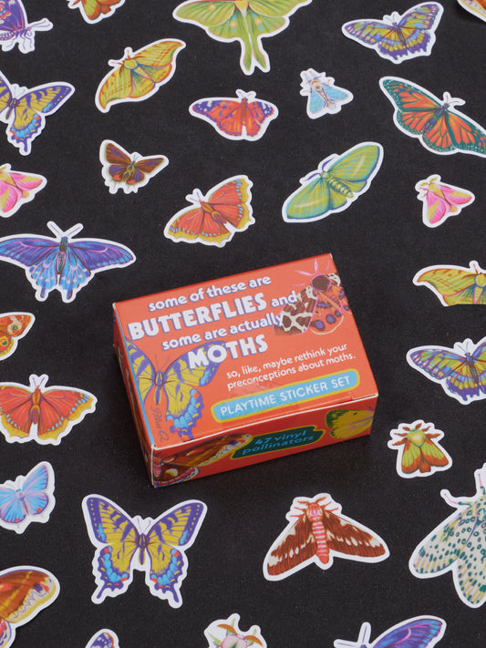 A box of the Blue Q Some Of These Are Butterflies And Some Are Actually Moths Playtime Sticker Set rests on a black surface adorned with vibrant butterfly and moth stickers, making it an ideal pick for lepidopteran enthusiasts ages 13 and up.