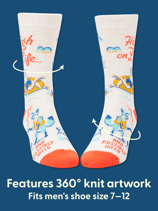 Blue Q High On Life...And Possibly Weed M-Crew Socks: Cream-colored combed cotton socks with orange toes featuring a 360° knit illustration of a blue fox lying on grass and the text "High on Life...and Possibly Weed." Fits men’s shoe size 7–12.