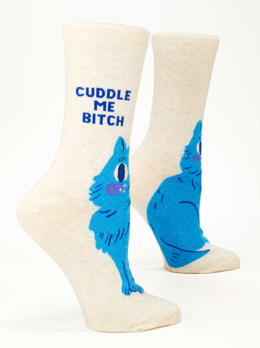The Blue Q Cuddle Me Bitch W-Crew Socks are cream-colored women's cotton socks with a blue cartoon cat and "CUDDLE ME BITCH" in bold blue letters—perfect for adding playful flair to any outfit.