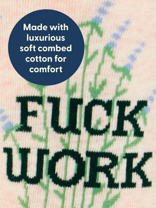 A close-up of the Blue Q “Fuck Work W-Crew Socks” showcases the bold black text “FUCK WORK” and a blue circle highlighting, “Made with luxurious soft combed cotton for comfort.” The background features green and blue plant designs accented with lavender hues.