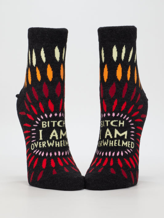 Blue Q’s Bitch I AM Overwhelmed W-Ankle Socks feature colorful teardrop patterns and bold text on black cotton, designed to fit women’s shoe size 5-10.