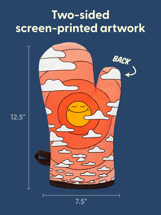 The Blue Q Somebody Get Me A Gummy Oven Mitt features a cheerful orange design with a smiling sun and clouds, measuring 12.5 inches tall by 7.5 inches wide to bring joy and ease to your kitchen routine. Displayed on a blue background with labeled dimensions and highlighted Two-sided screen-printed artwork text.