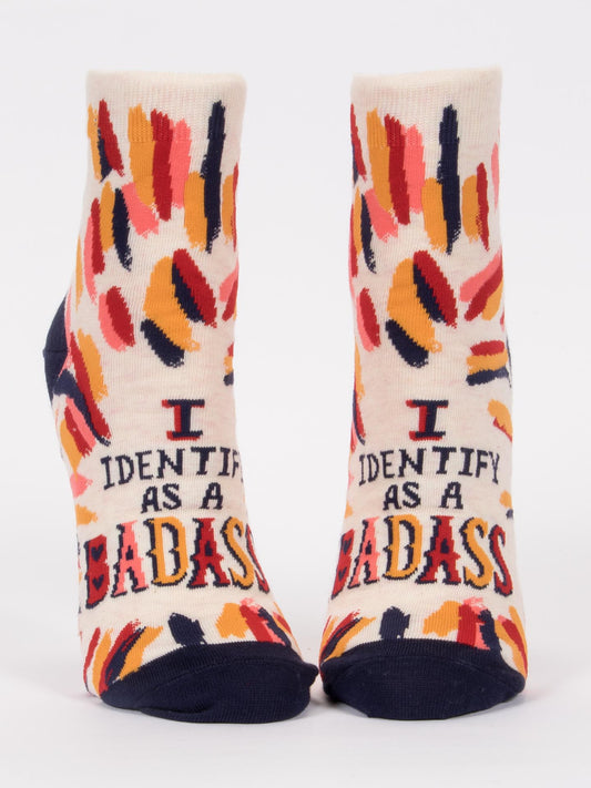 Blue Q’s I Identify As A Badass W-Ankle Socks feature colorful brushstroke patterns, bold text, and navy toes, heels, and cuffs—perfect for making a True You style statement.