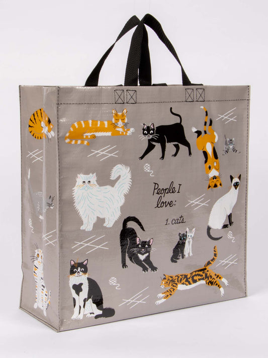 The Blue Q People I Love: Cats Shopper is a reusable tote with black handles, colorful cat love illustrations, and the text "People I love: 1. cats." on a light gray background.