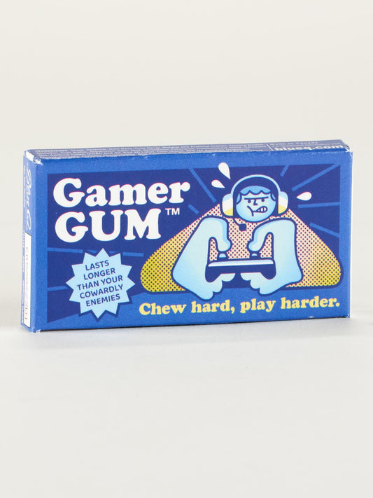 A blue box of Gamer Gum by Blue Q shows a cartoon with a headset and controller, plus “Chew hard, play harder” and “Lasts longer than your cowardly enemies.” Enjoy the intense kick of cinnamon-flavored, candy-coated gum.