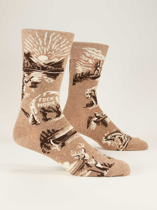 Blue Q’s Fuck Work M-Crew Socks are tan novelty socks with a nature scene—mountains, trees, animals, and a rising sun—plus "FUCK WORK" in bold white letters.