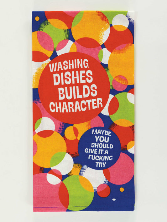 The Blue Q "Washing Dishes Builds Character. Maybe You Should Give It A Fucking Try." Dish Towel features colorful overlapping circles in red, orange, yellow, green, pink, and blue with bold, cheeky text for a fun kitchen accent.