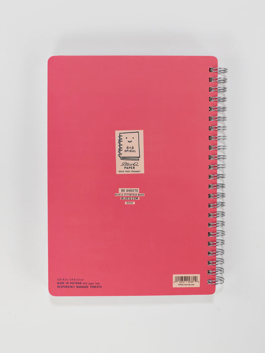The Blue Q "I Was Put On This Earth To Twirl My Hair And Disagree" 6x8 spiral notebook, shown closed with a labeled cover, rests on a white background—ideal for pairing with your favorite decor or inspirational wall art.