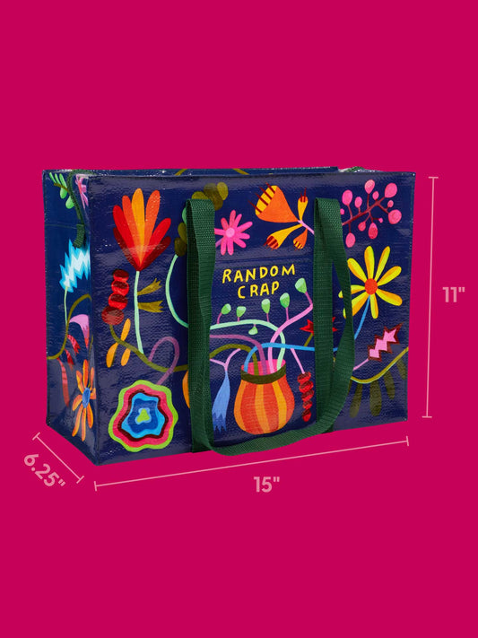 The Blue Q Random Crap Shoulder Tote is a colorful rectangular bag with “RANDOM CRAP” on the front, vibrant flowers and abstract designs, green handles, and measures 15" W x 11" H x 6.25" D—perfect for fun organization.