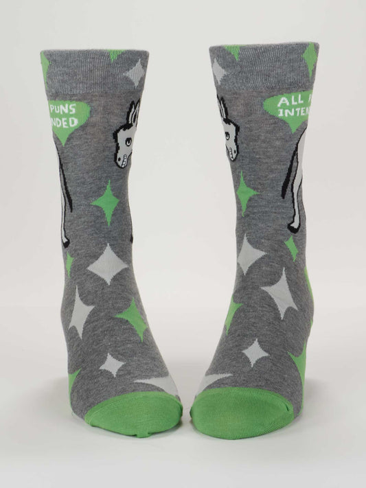 Blue Q’s All Puns Intended M-Crew Socks are gray combed cotton with green toes and heels, white and green star patterns, a cartoon animal detail, and “ALL PUNS INTENDED” on the cuffs.