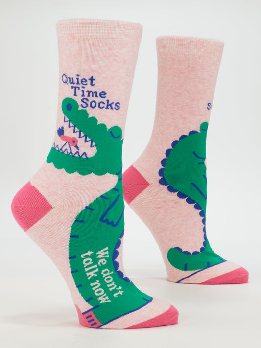 Blue Q Quiet Time Socks, We Don't Talk Now W-Crew: Two pink women's socks with green cartoon alligators, blue and dark pink accents. One sock says "Quiet Time Socks" near the top, the other "We don’t talk now" by the toe—a playful, fun design.
