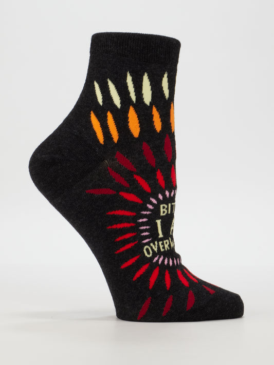 Blue Q's Bitch I AM Overwhelmed W-Ankle Socks for women (shoe size 5-10) are black cotton with vibrant teardrop patterns and bold white "BITCH I AM OVERWHELMED" text on the side.
